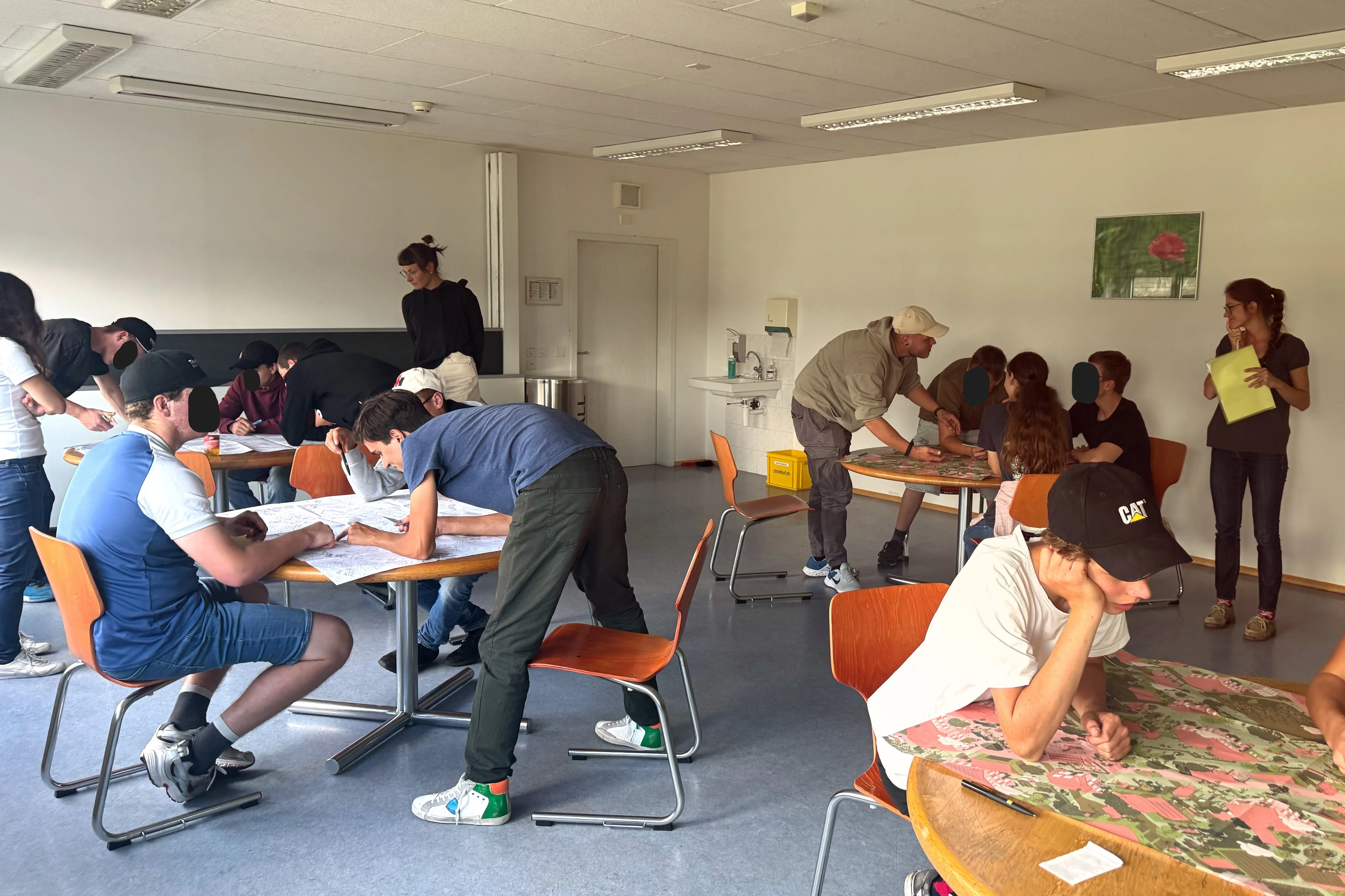 The picture shows Strickhof students trying out the game at different tables.