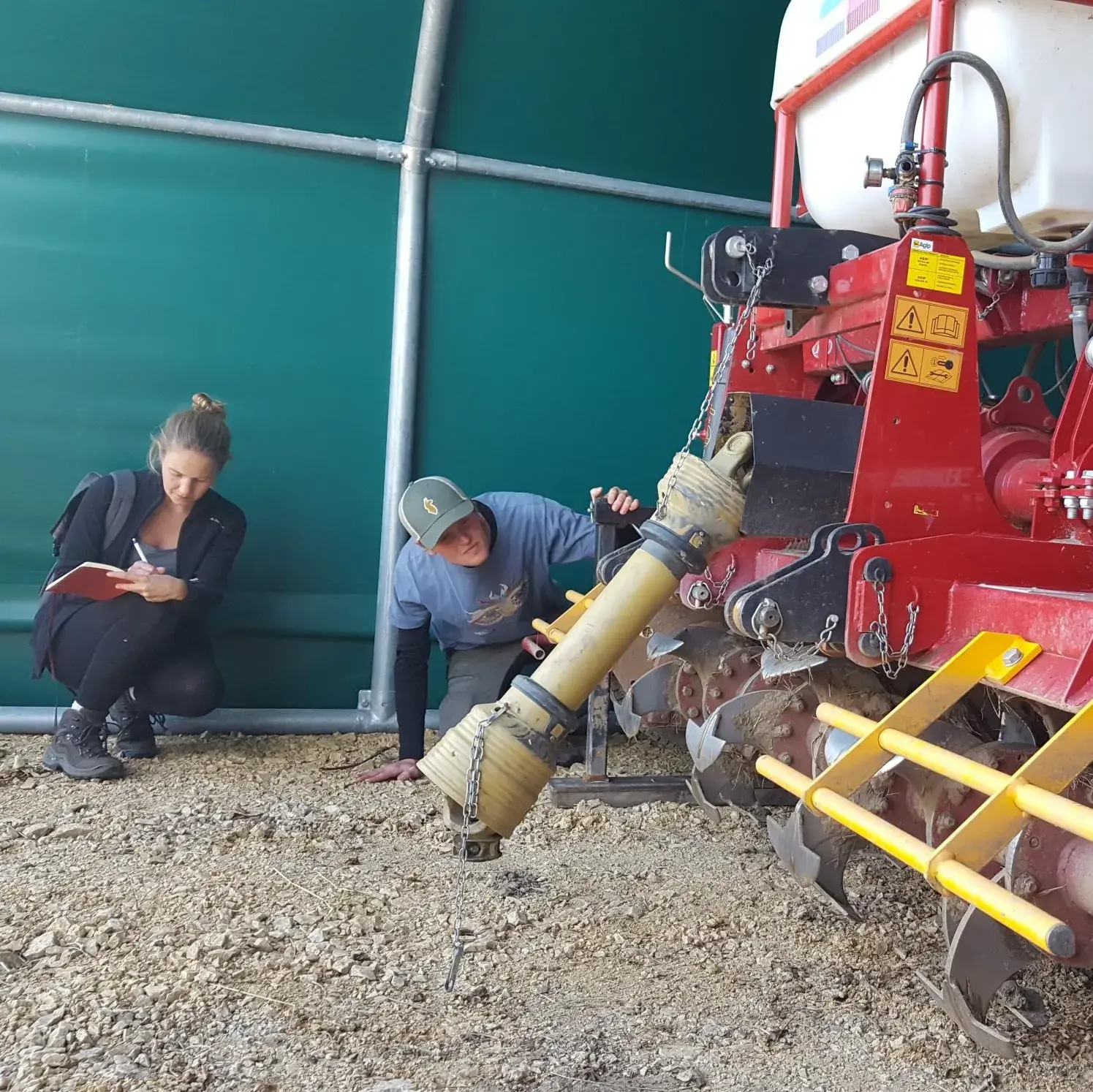 Studierende inspizieren die Funktionsweise des Geohobels zur Grundbodenbearbeitung