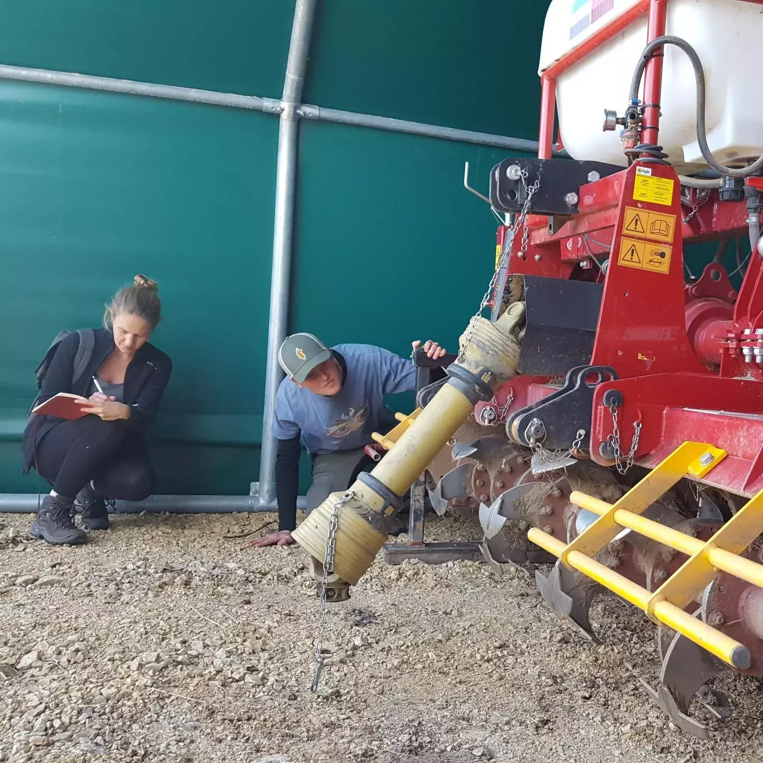 Studierende inspizieren die Funktionsweise des Geohobels zur Grundbodenbearbeitung