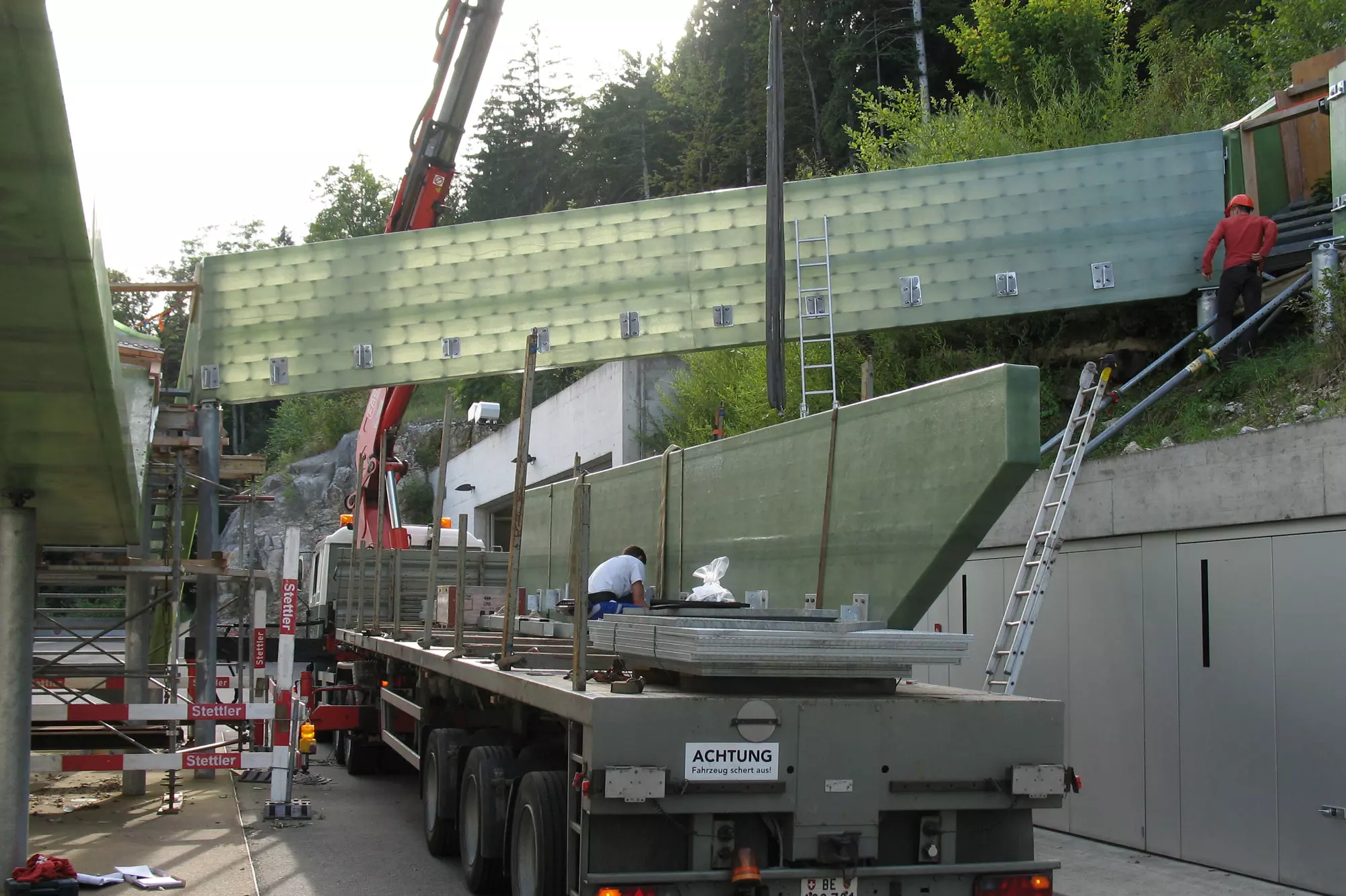 Passerelle Magglingen (PSM-Modul) Die punktuellen kreuzförmigen Aussteifungen des Platten-Scheiben-Moduls PSM erscheinen durch das transluzente Material im Gegenlicht als Musterung.