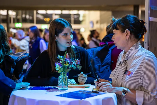 Bild vergrössern: Zwei Teilnehmende am Stehtisch im angeregten Gespräch