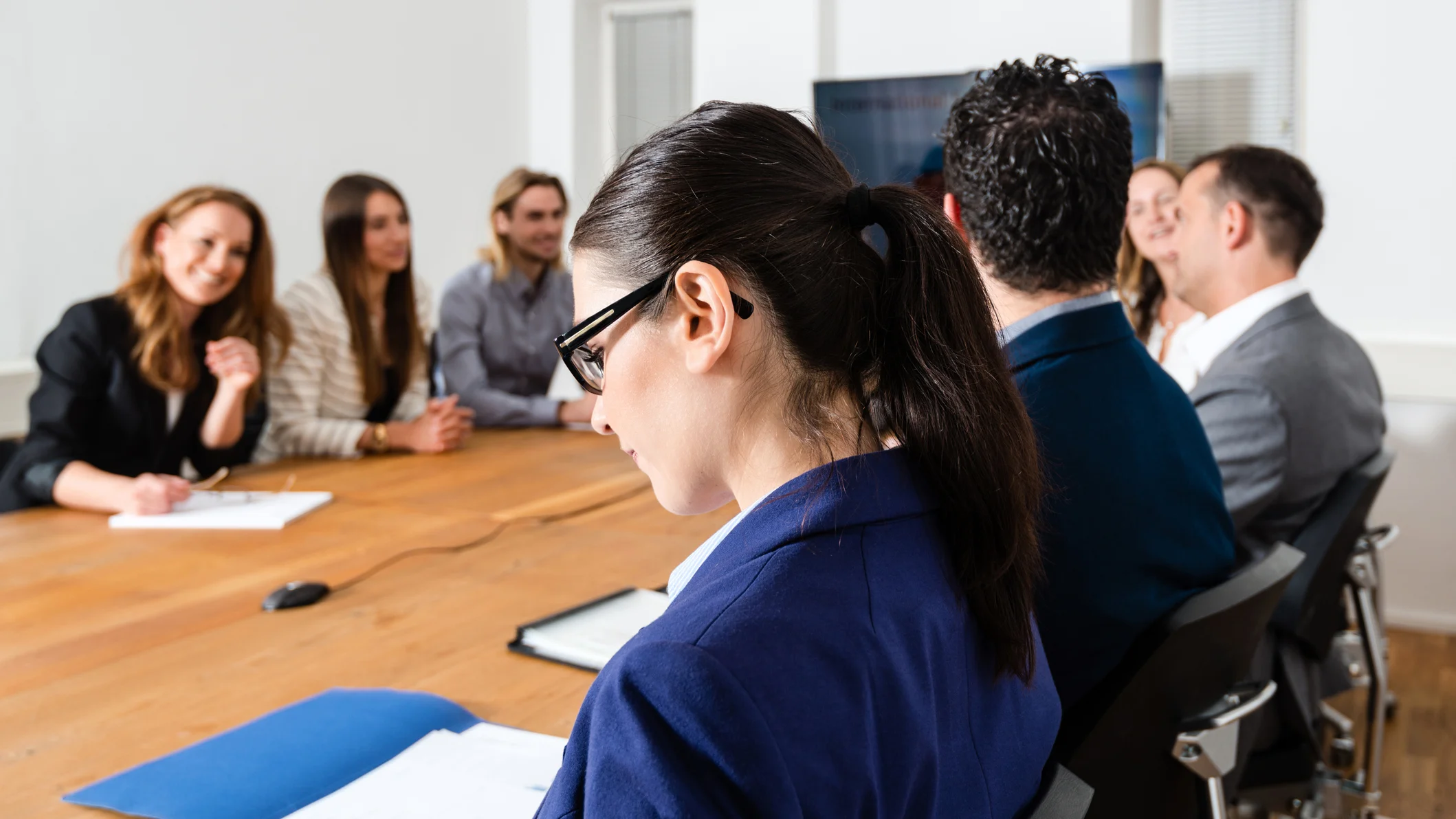 A group of people in business attire is sitting around a table.