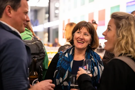 Bild vergrössern: Drei Personen unterhalten sich lachend