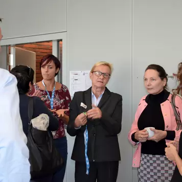 Kaffeepausenraum. Susanne Jekat, Christiane Hohenstein und eine Gruppe Konferenzeilnehmende unterhalten sich während der Kaffeepause.