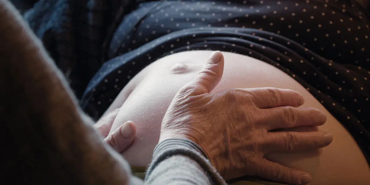 Eine Hebamme tastet den Bauch einer schwangeren Frau ab. Eine Hebamme tastet den Bauch einer schwangeren Frau ab.