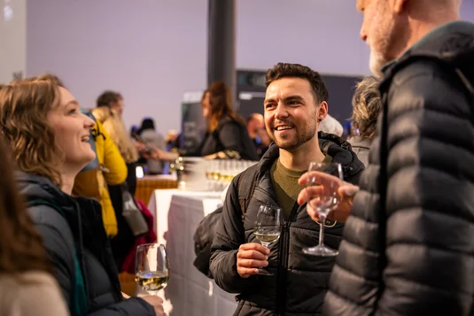 Bild vergrössern: Drei Personen beim Apero haben Getränke in der Hand und tauschen sich angeregt aus