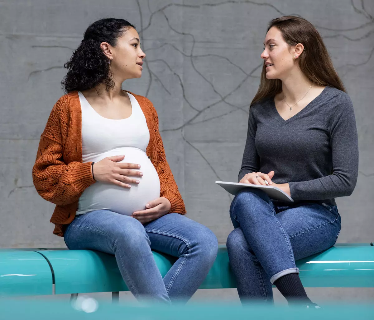 Eine Schwangere und eine Studentin im Gespräch.