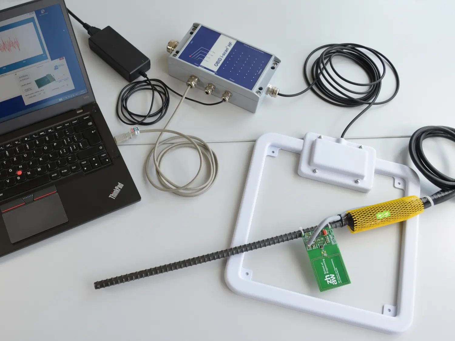 Die Komponenten des Messsystems: Stahl mit Dehnmessstreifen, Sensor, Antenne, Reader und PC.