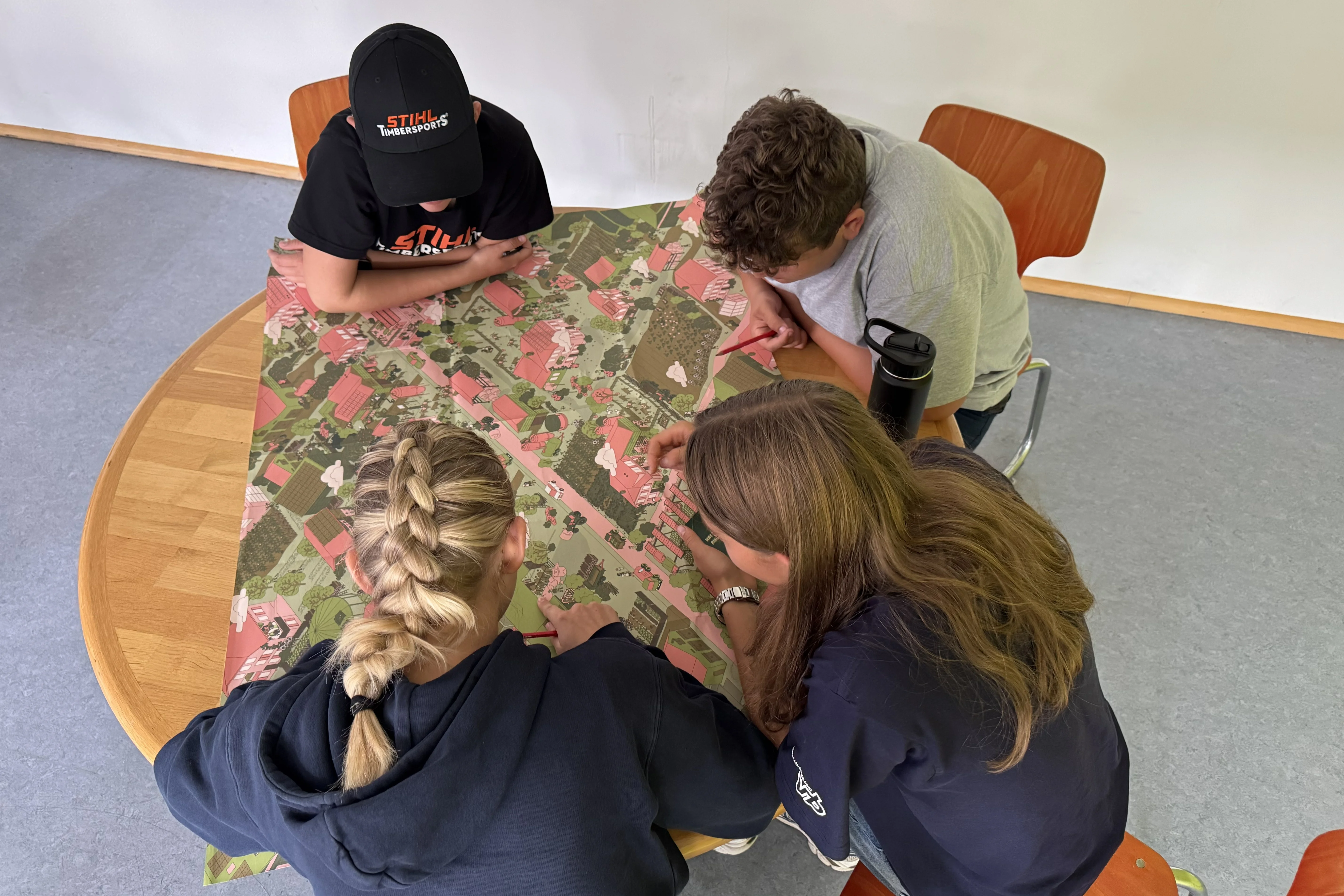 A group of four students is looking at the game board.