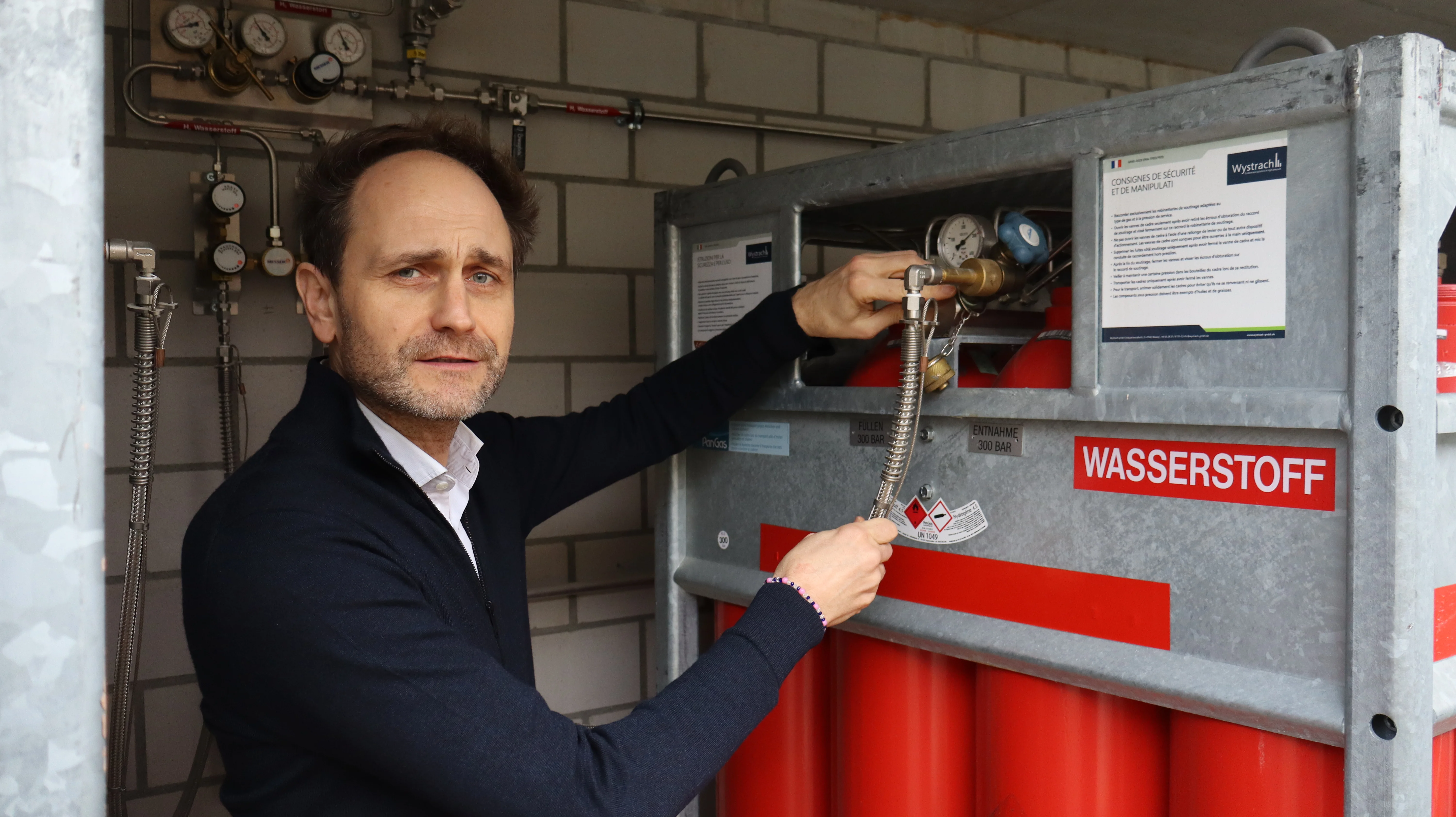 Mirko Bothien erklärt, wie der Wasserstoff im Wasserstofflager angeschlossen und mit dem Labor verbunden ist.