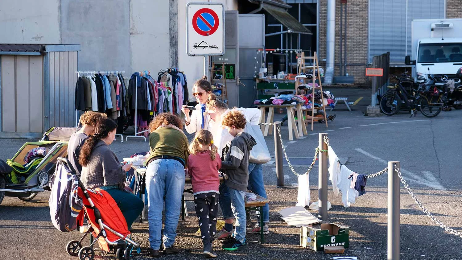 Ein Gruppe Menschen steht auf einem Flohmarkt und diskutiert miteinander.