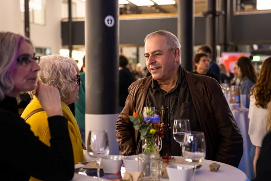Bild vergrössern: Teilnehmende beim Apero im Gespräch sowie weitere Gäste beim Networking