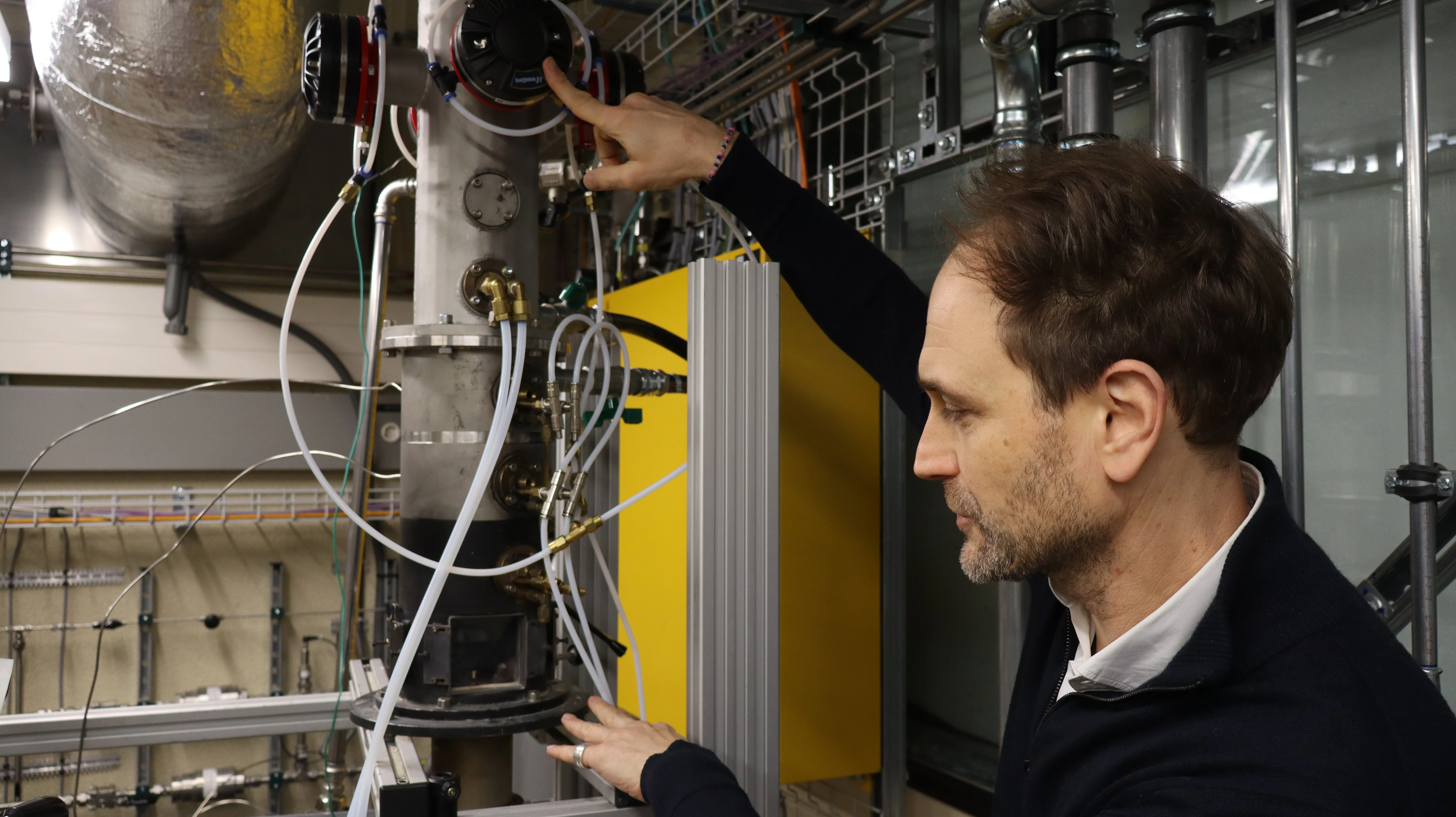 Mirko Bothien erklärt im Labor die Funktionsweise des Prüfstandes für die Wasserstoffverbrennung.