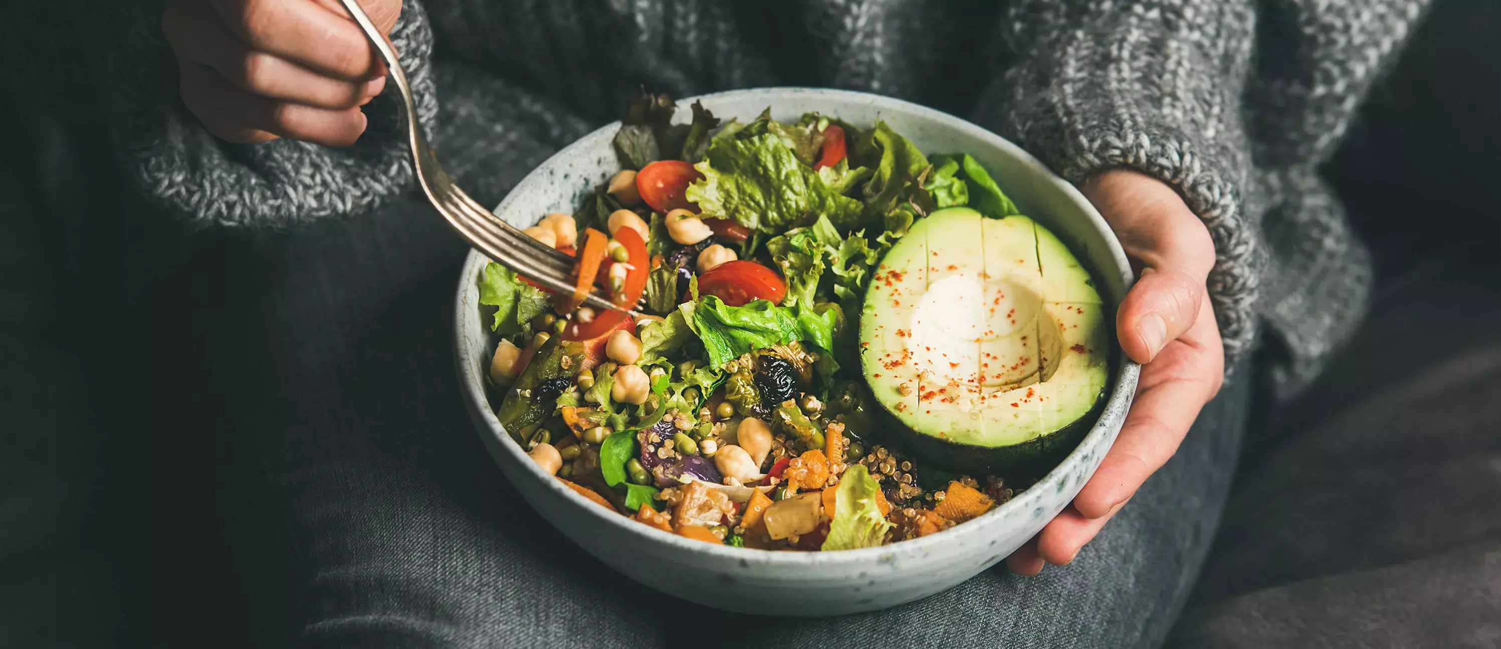 Woman eating healthy vegetarian dinner from Buddha bowl, close-up