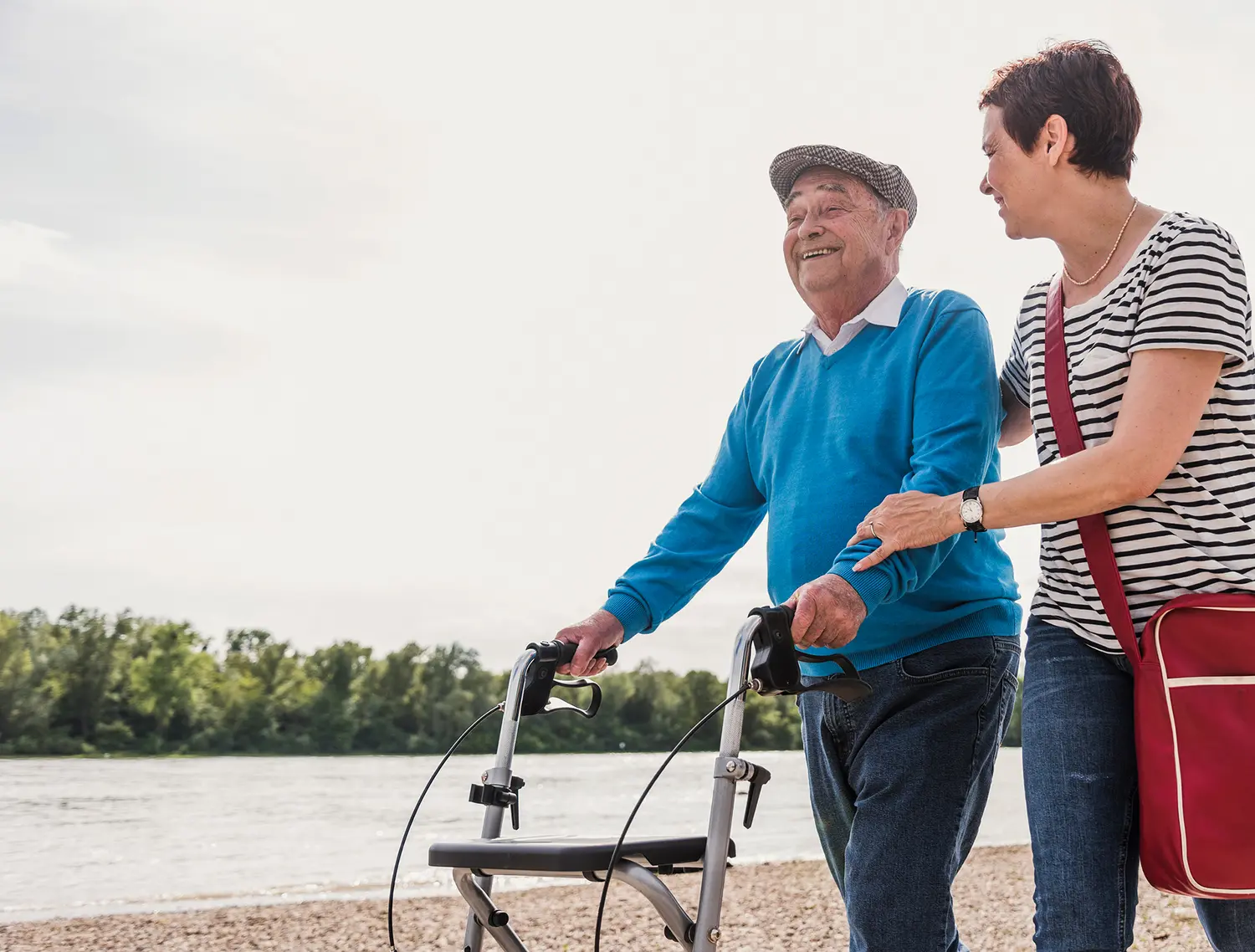 Tochter führt Vater am Rollator spazieren