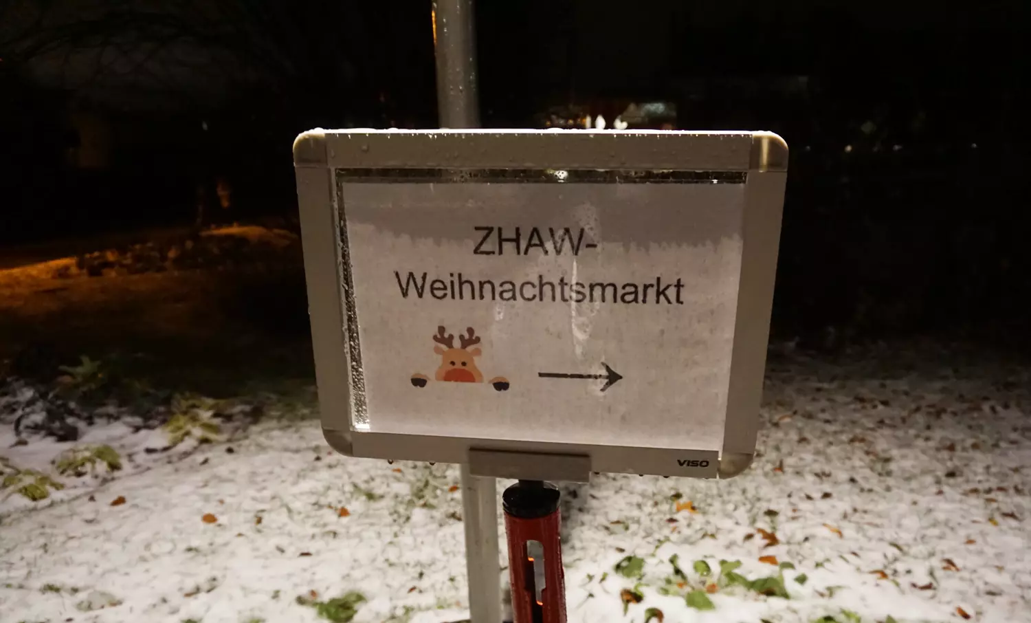 Ein Schild, das im Schnee steht und auf dem ZHAW-Weihnachtsmarkt steht.