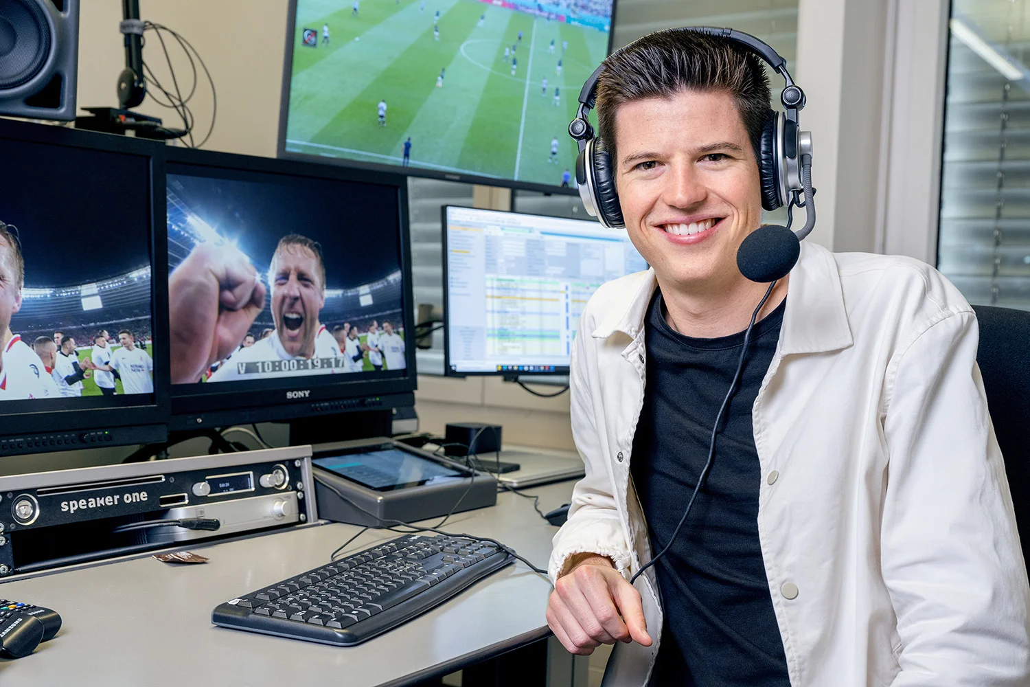 Calvin Stettler mit Headset an einem Kommentatorenpult im Studio