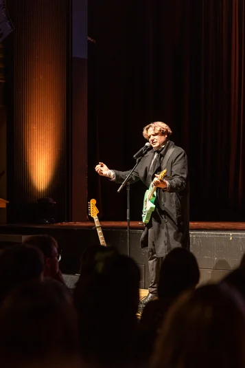 Bild vergrössern: Der Musiker Aaron Asteria steht im Spotlight auf der Bühne und hält eine Gitarre.