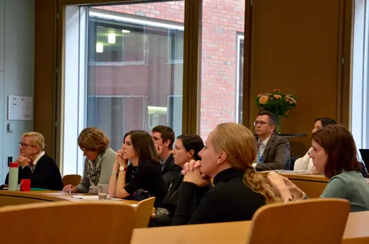 Hörsaal. Eine Gruppe von Teilnehmenden in den Hörsaalreihen während eines Vortrags.
