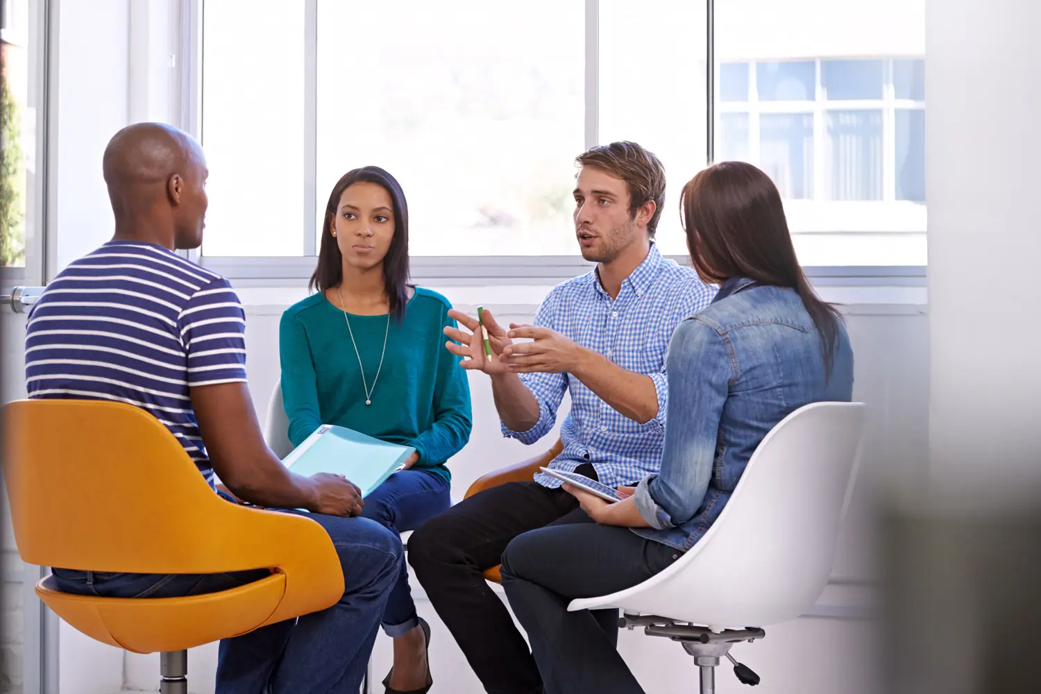 Vier Personen sitzen zusammen und besprechen etwas.