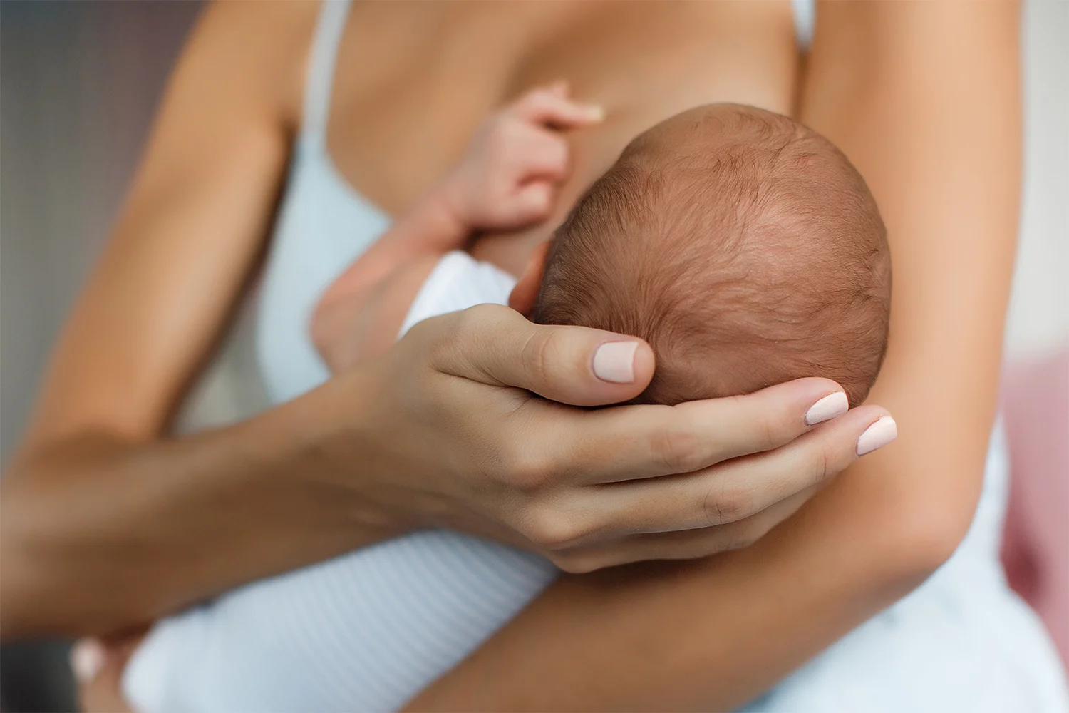 Frau mit einem Baby im Arm, das gestillt wird.