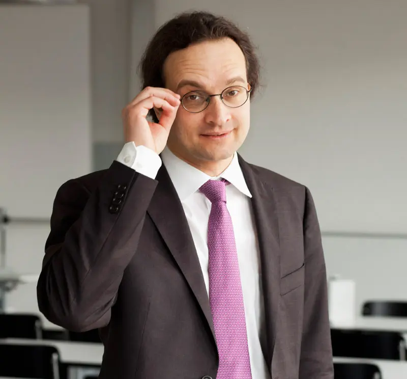 Porträt von Peter Schwendner stehend in Unterrichtsraum