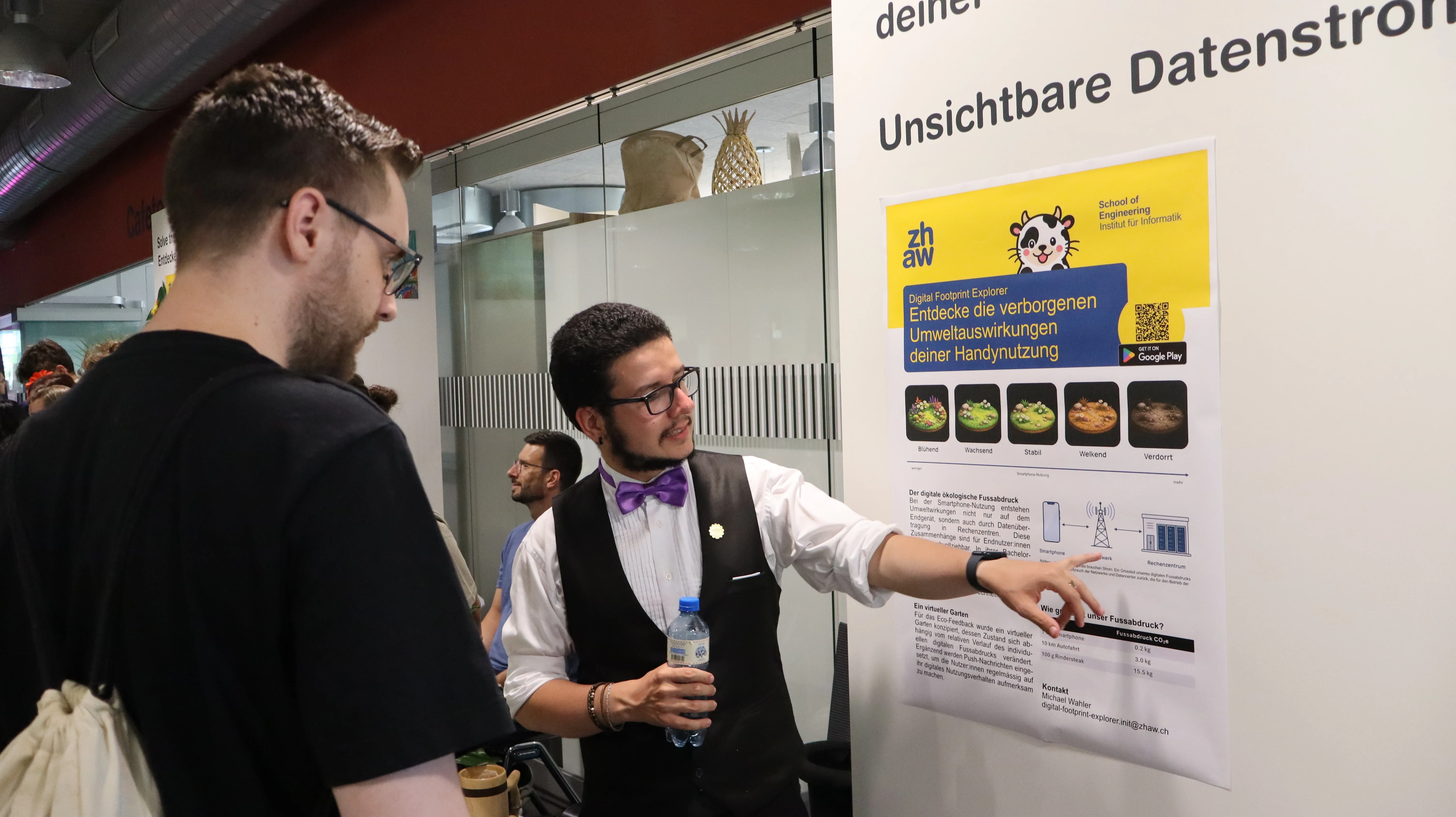 Der Verfasser der Bachelorarbeit stellt diese einem Besucher an der Nacht der Technik vor.