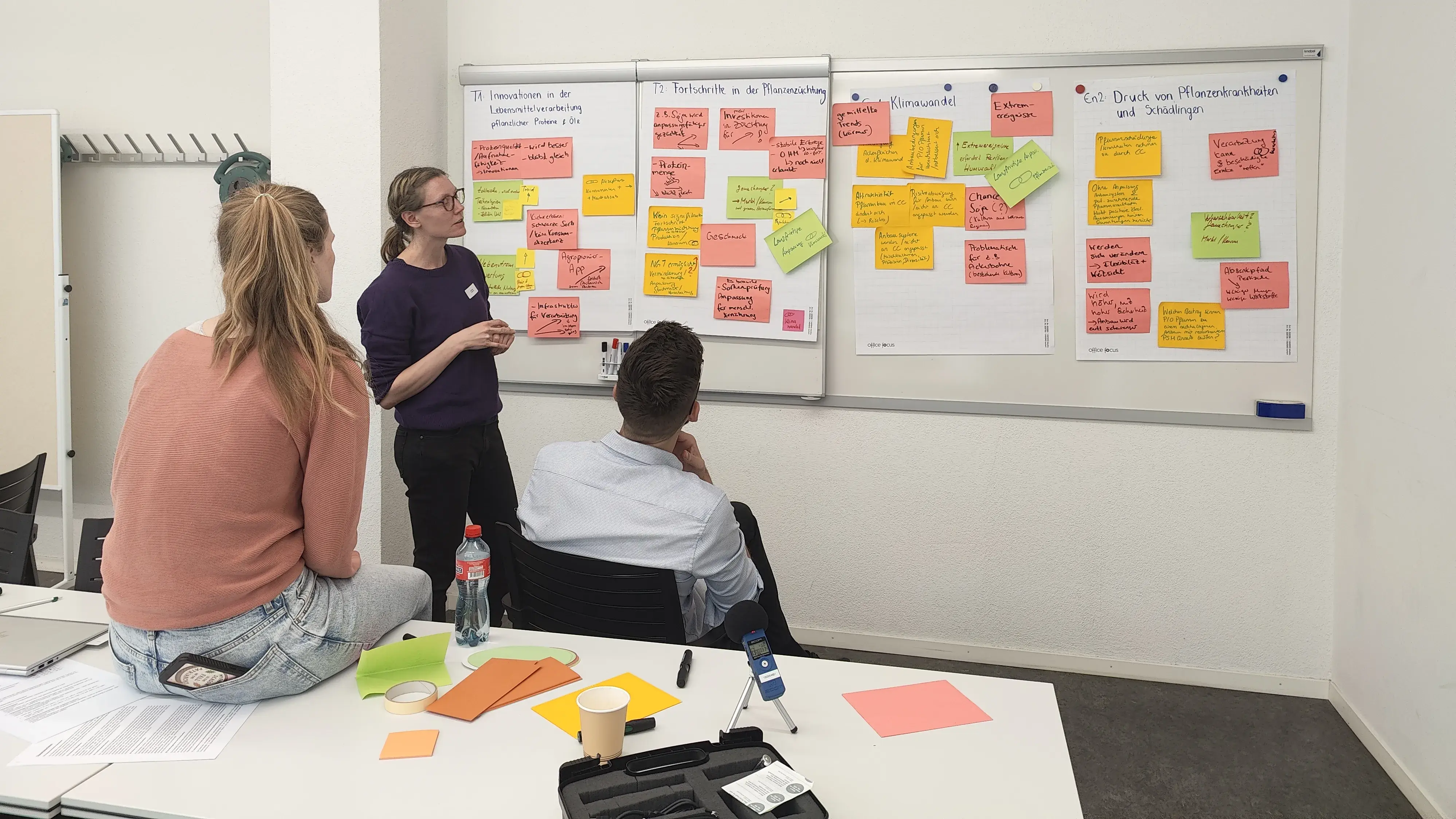 Teilnehmende des Workshops diskutieren einzelne Treiber mit Hilfe von Zetteln.