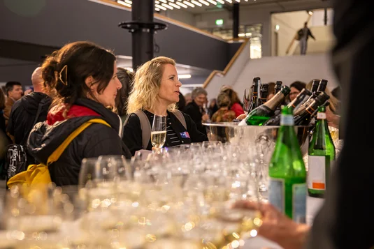 Bild vergrössern: Mehrere Personen stehen an der Bar für Drinks