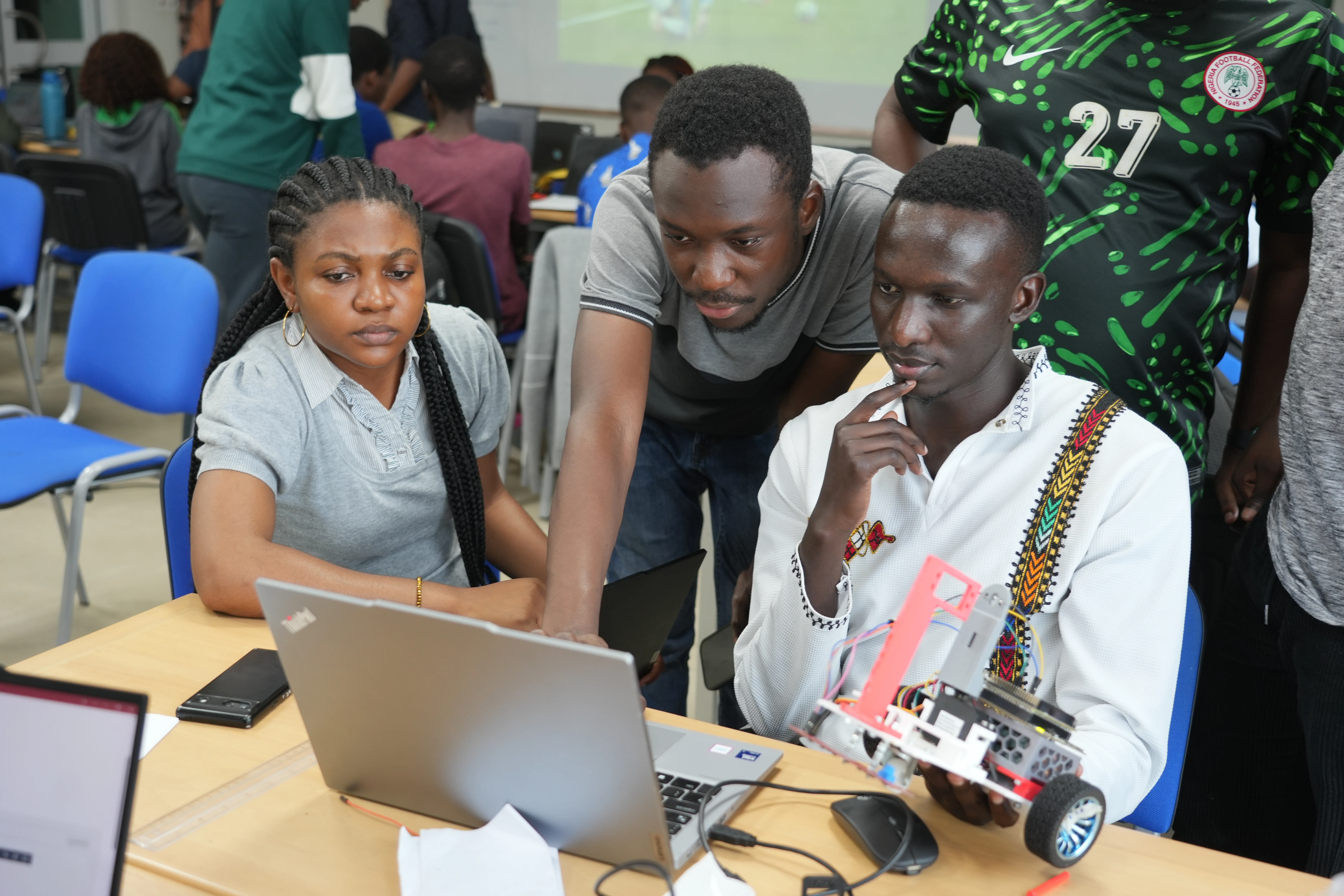 Drei Studierende der Ashesi University entwickeln und planen ihren Roboter am Laptop.