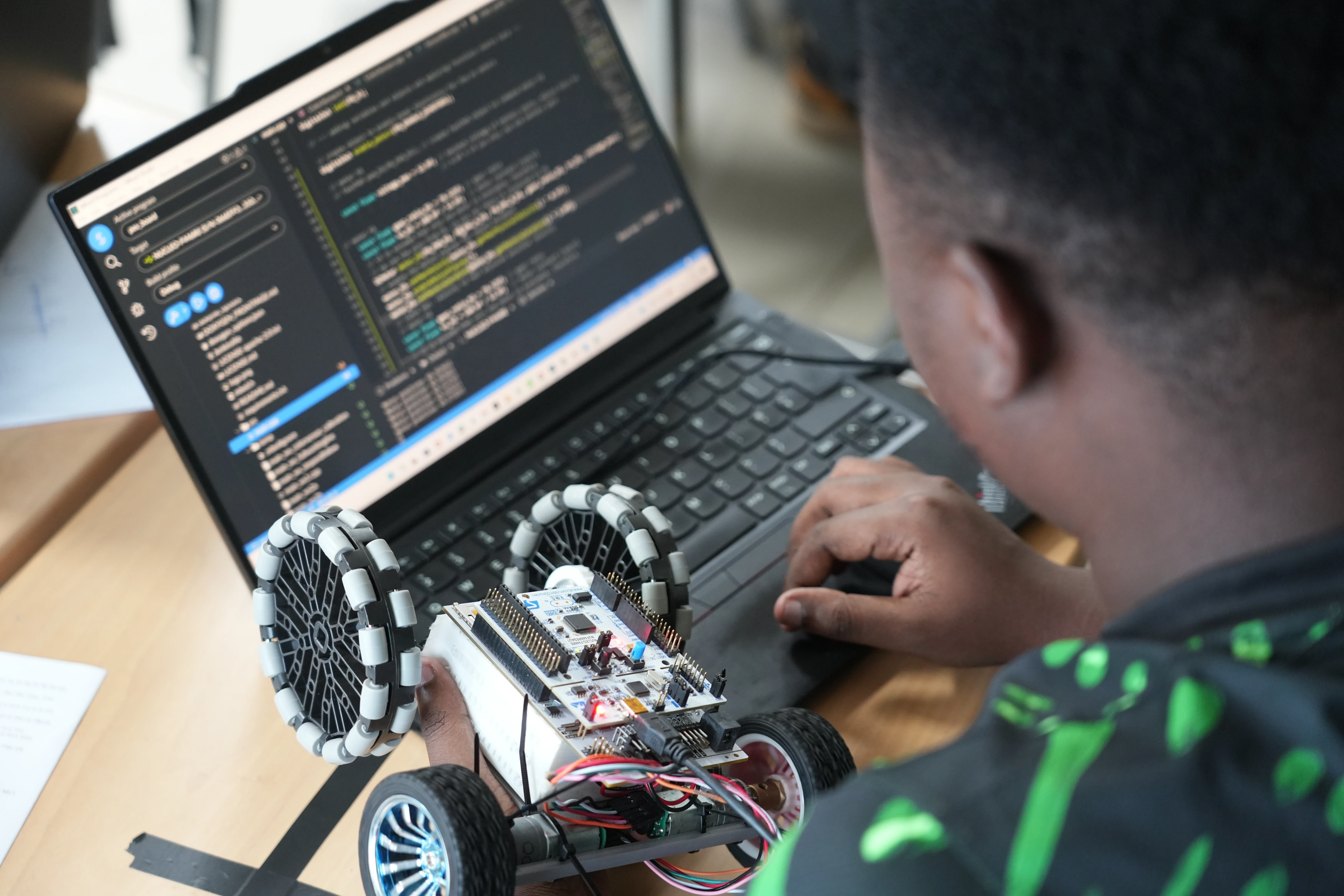 Ein Studierenden überprüft die aufgezeichneten Daten seines Roboters am Laptop.