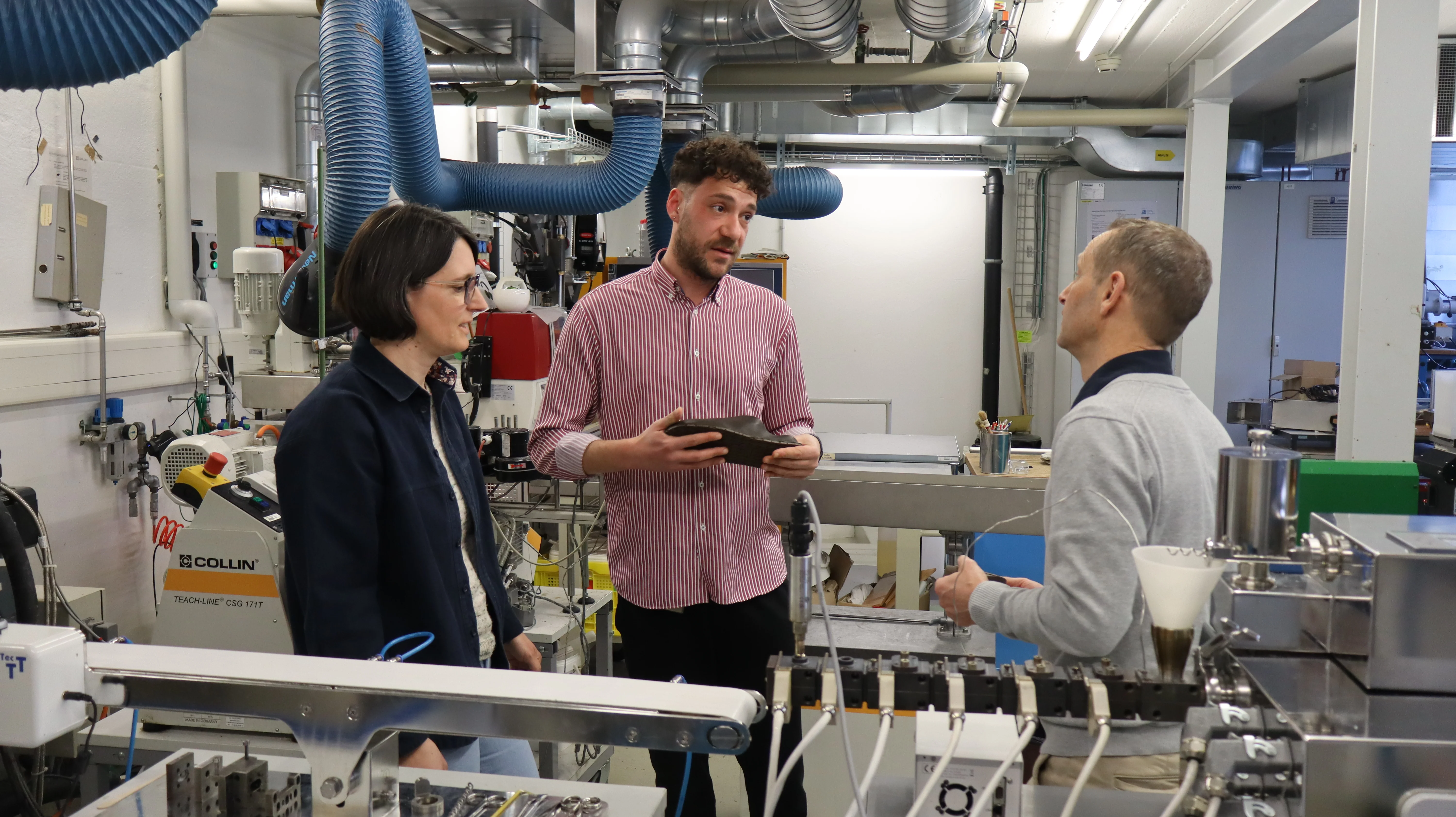 Das Team diskutiert über das Material der Schuhsohle im Labor.