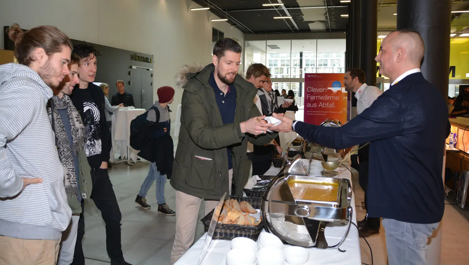 Studierende und Mitarbeitende stehen vor dem Suppenbuffet in der Empfangshalle des Toni-Areals und holen sich einen Teller Suppe.
