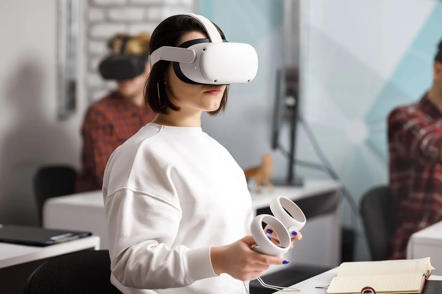 team of four creative engineers working with virtual reality, young woman testing VR glasses or goggles sitting in the office room team of four creative engineers working with virtual reality, young woman testing VR glasses or goggles sitting in the office room