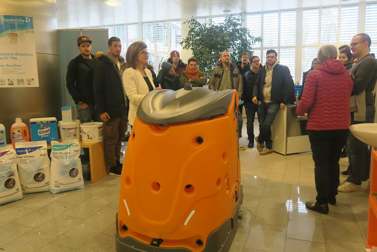 Studierende des Bachleorstudiengang in Faciltiy Management stehen um einen Reinigungsroboter der Firma Diversey in Münchwillen und lassen sich das Gerät erklären