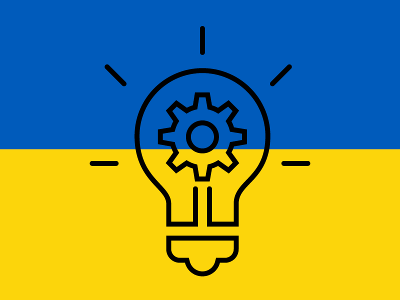 Das Bild zeigt die ukrainische Flagge mit einer Glühbirne im Vordergrund.