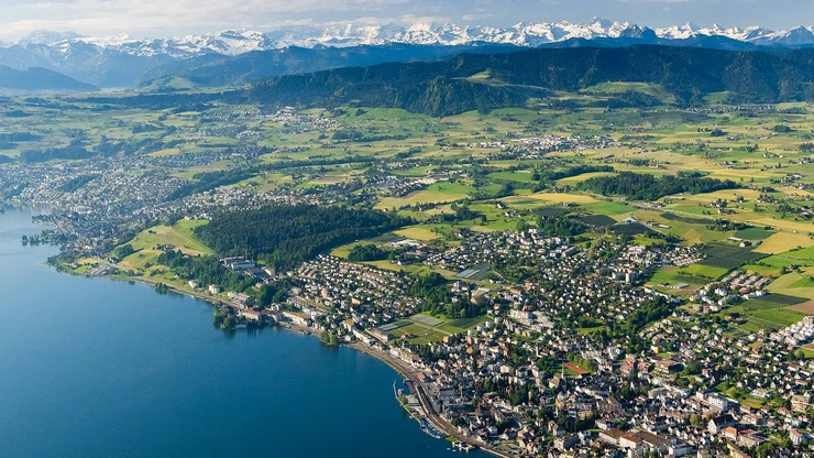Luftaufnahme von Wädenswil mit Blick auf den Zürichsee und die Alpen.